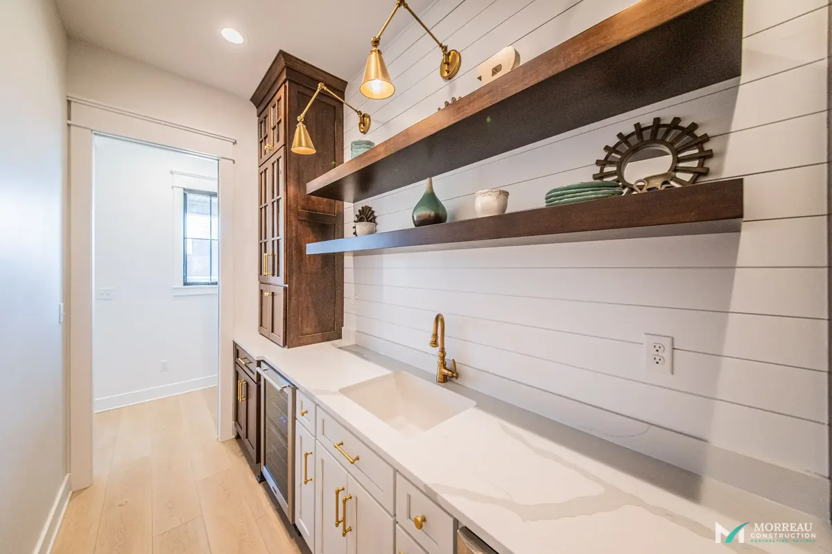Butler's pantry with floating shelves and brass fixtures