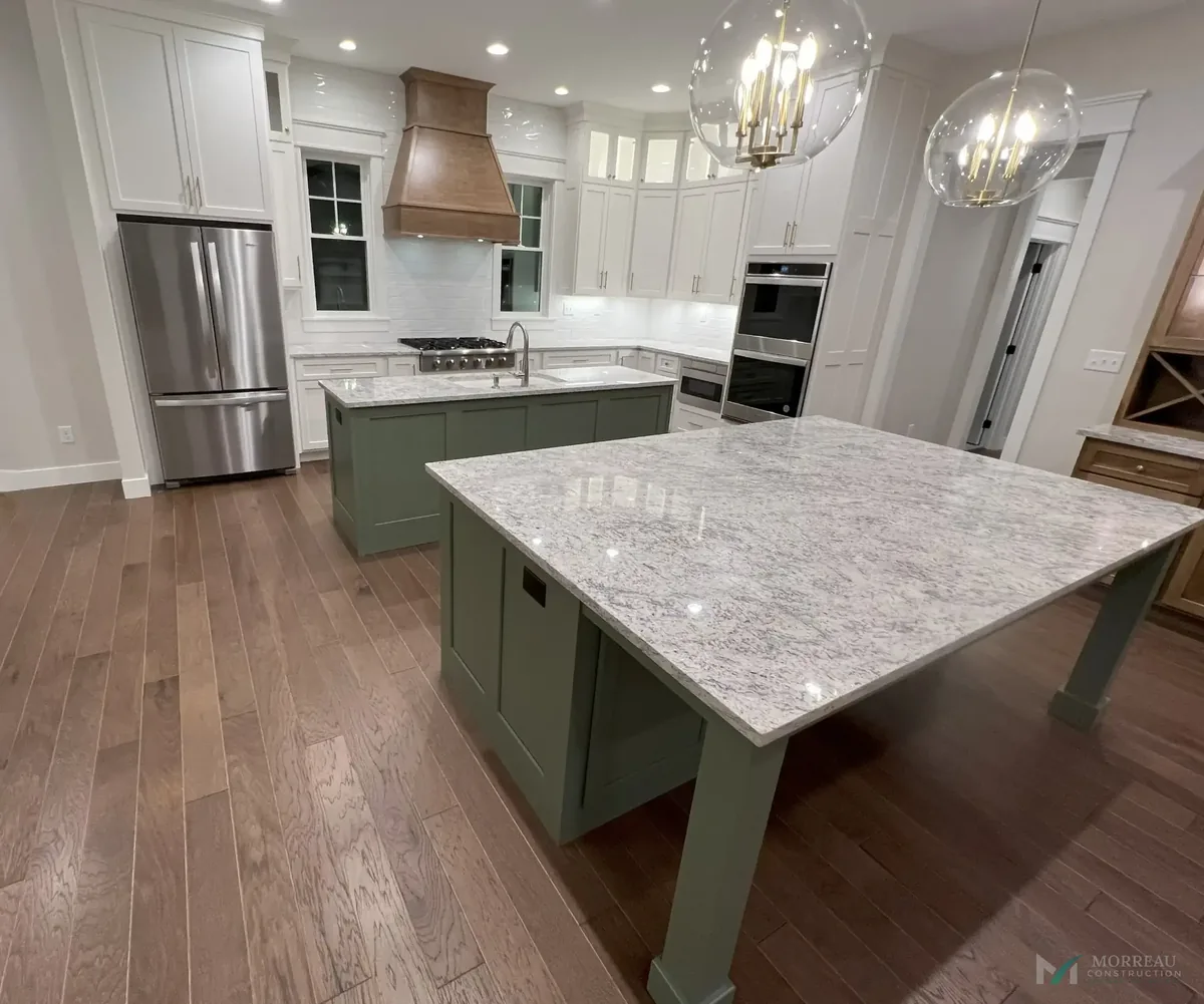 Kitchen with white and walnut cabinetry and gold pendants