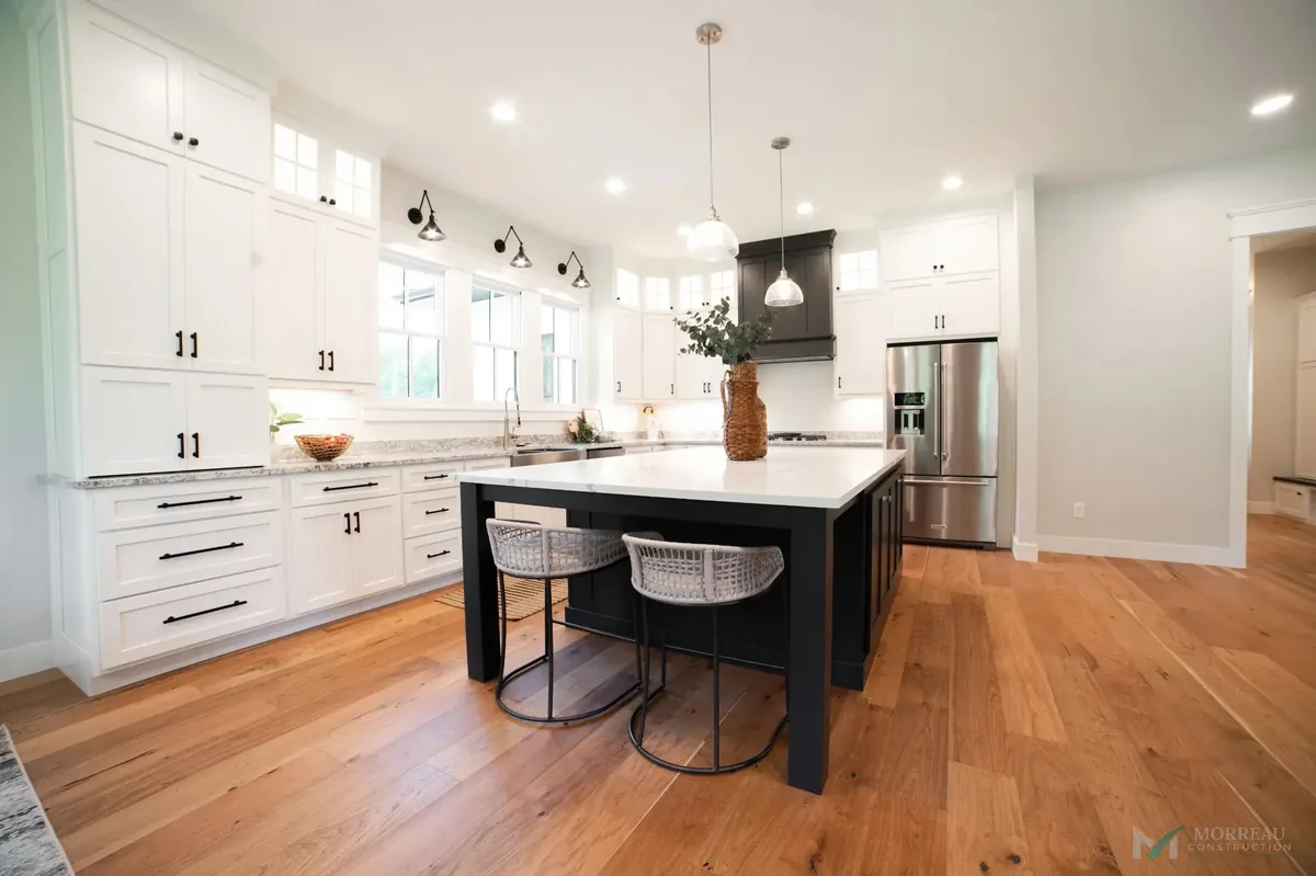 Kitchen with white cabinets and black island